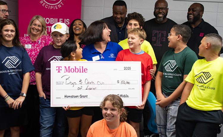 Members of the Tim Lee Boys and Girls Club, the organization’s leadership team, and representatives from T-Mobile stand around the giant $50,000 T-Mobile Hometown Grant check, which helped the Boys and Girls Club of Lanier to purchase much-needed electronics for both the Habersham club and their satellite locations in the school system. (Hannah Caudell/Staff)