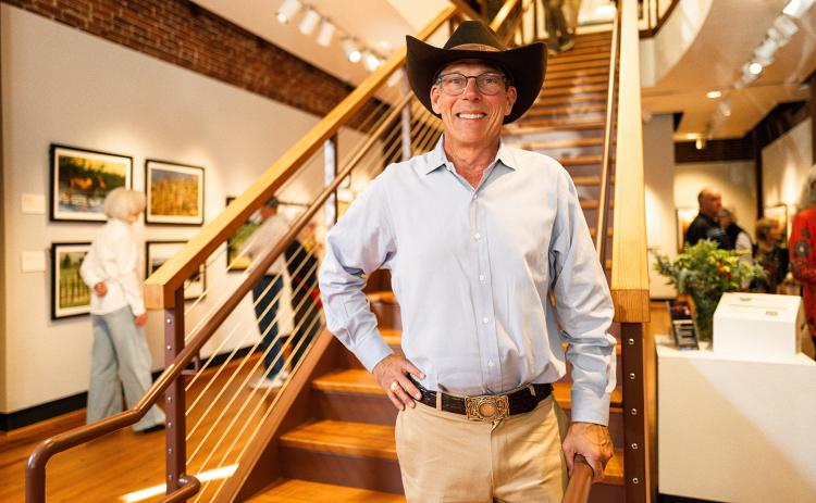 Photographer and filmmaker Rhett Turner poses for a photo on the staircase of the Mason-Scharfenstein Museum of Art, where his exhibit is currently on display. (Zach Taylor/Staff)