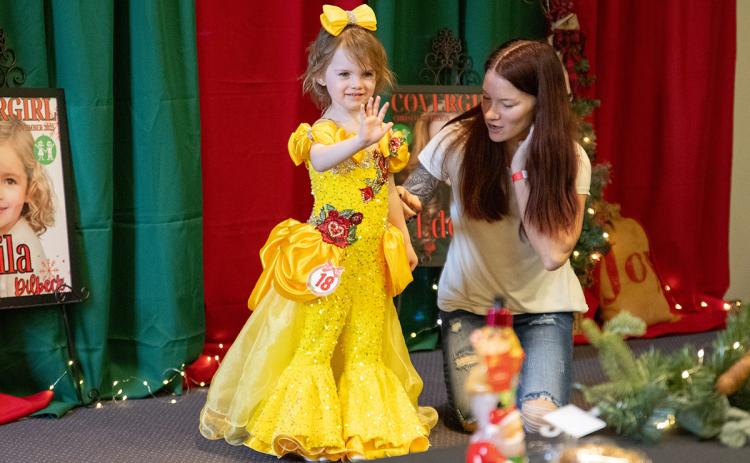 Braylin Winkles waves to the judges and the crowd during the princess dress portion of the pageant. (Zach Taylor/Staff)