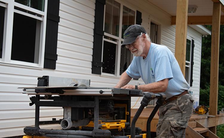Habitat for Humanity volunteer John Ott cuts flooring to fit into one of the new Habitat homes on the Clarkesville property. Habitat for Humanity of Northeast Georgia is one of the housing nonprofits affected by the government shutdown, which ended Wednesday evening. (Hannah Caudell/Staff)