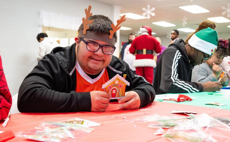 Ethan Ortiz proudly shows his colored gingerbread house at the Hillside Baptist Church Autism Christmas event. (Zach Taylor/Staff)