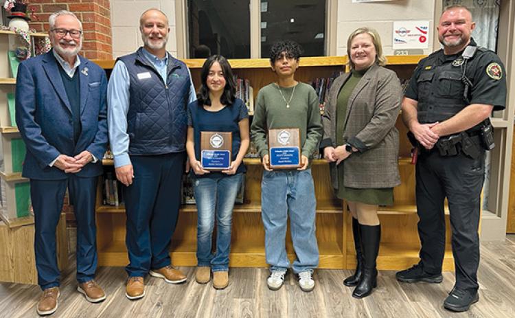 John Fair of Peachstate Federal Credit Union, Scott Roland of Peachstate Federal Credit Union, Nicole Dover of Habersham EMC and Habersham Sheriff Deputy Aaron Autry honor Wilbanks Middle School’s REACH Scholars Jasmine Solorzano and Daniel Martinez. (Submitted)