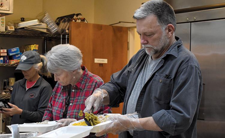 Claudia Jessup and Brant Finley work together to prepare meals at the First Presbyterian Church on Christmas Day. (Samantha Sinclair/Staff)