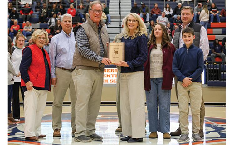 Left to right: Mother, Margaret Tench, husband, Stan Gunter, HCHS Athletic Director Geep Cunningham, Rita Tench Gunter, dad, Charles Tench (hidden), granddaughter Cayden, son Chase and grandson Westin pose during the basketball hall of fame ceremony at the Raider Gymnasium on Friday, Dec. 19. (Landen Todd/Staff)