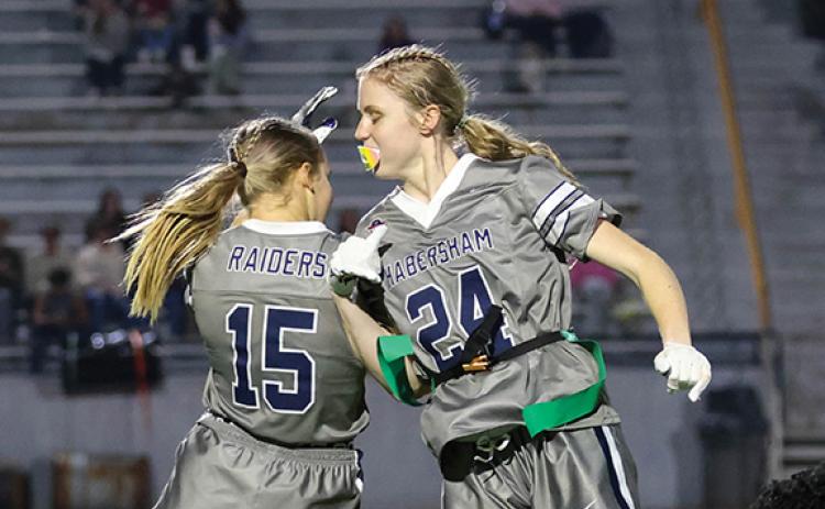 Habersham Central sophomore receivers Macy Huff (15) and Tessa Murdock (24) jump up in celebration during a flag football game at Raider Stadium on Wednesday, Nov. 19. (Landen Todd/Staff)