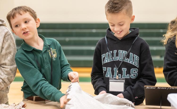 TFS Fourth graders Taylor Peckham and Decklan Densmore work to tie blankets for the animal shelter. (Zach Taylor/Staff)