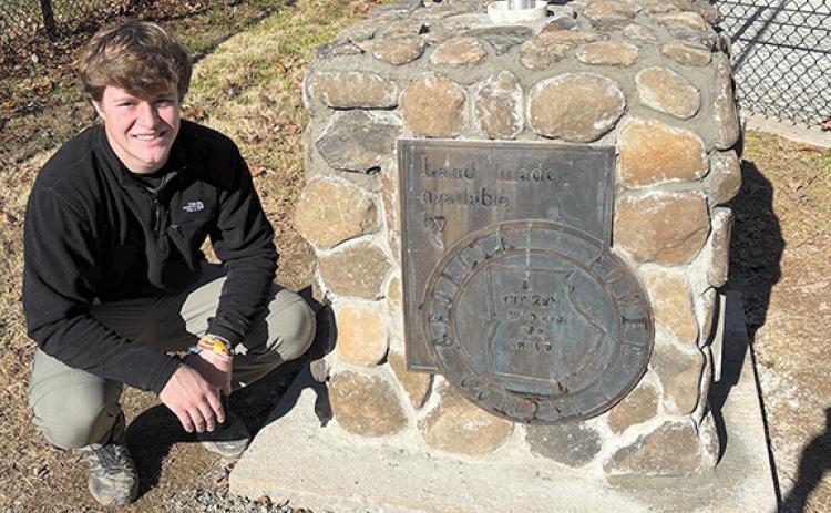 Sawyer Burgess proudly shows the completed stone pedestal with a bronze plaque noting the land for the Lake Burton Fish Hatchery was provided by Georgia Power. (Submitted)
