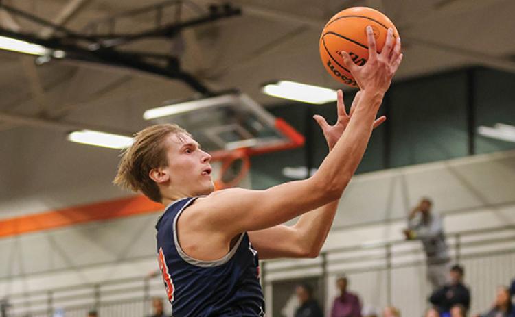 Left, Habersham Central senior forward Judge Wilbanks (13) goes up for a basket during the Mcdonald’s Shootout final at Hart County High School on Tuesday, Dec. 30. Right, Habersham Central junior guard Micah Huff (1) pumps his fist in celebration during the McDonald’s Shootout final. (Landen Todd/Staff)