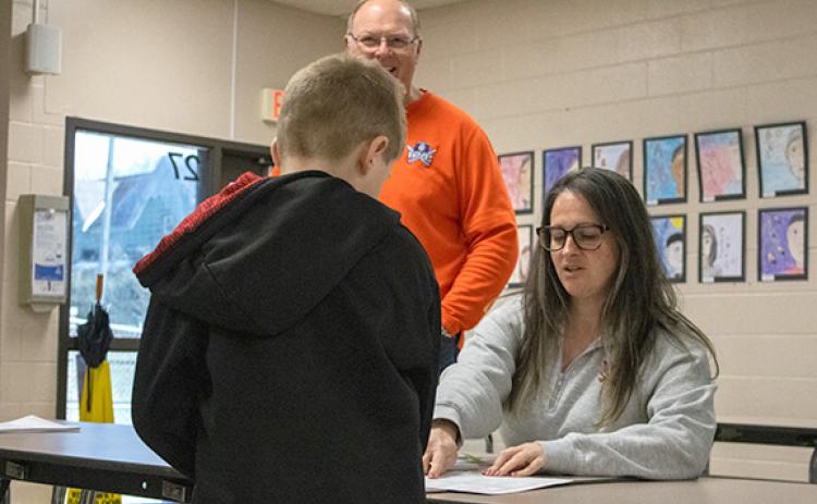 Baldwin Elementary Assistant Principal Alexandria Noggle hands packets out to students on Friday, Jan. 30 ahead of a new winter weather system after the county just recovered from Winter Storm Fern. (Hannah Caudell/Staff)