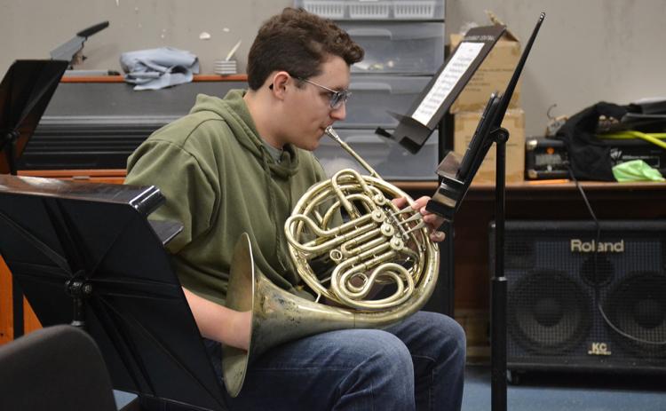 Christian Moore practices playing the French horn during band class at Habersham Central High School on Wednesday. (Samantha Sinclair/Staff)