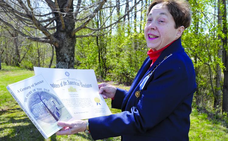 Delores Anderson shows her Daughters of the American Revolution membership certificate and her copy of A Century of Service: The Story of DAR. The year she joined was the centennial year of the society. Samantha Sinclair/Staff