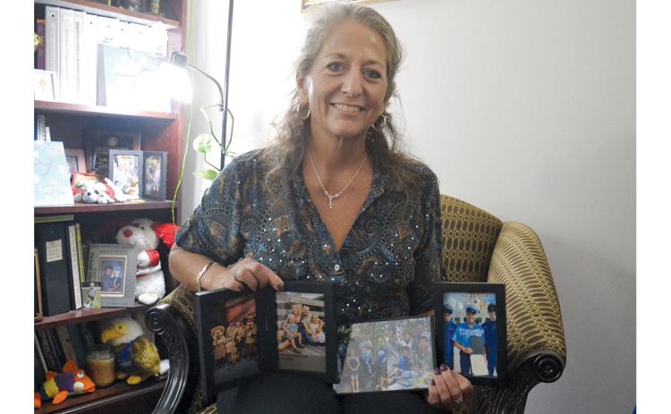 Dr. Fran Chastain shows some of her favorite photos of her 13 children and nine grandchildren in her office at North Georgia Technical College. She has 13 children, 11 of which were adopted. (Samantha Sinclair/Staff)