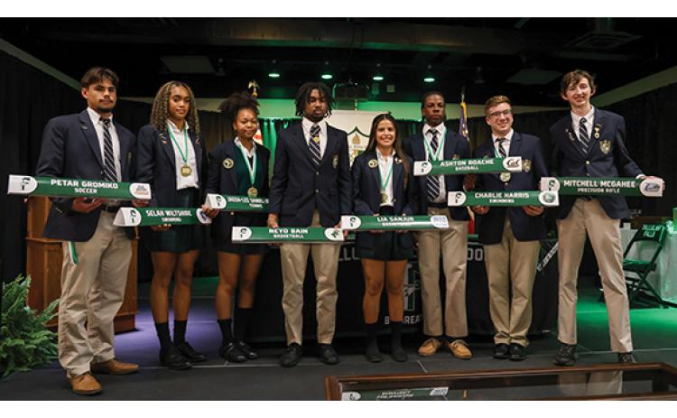 TFS student-athletes Petar Gromiko, Selah Wiltshire, Jaeda-Lee Daniel-Joseph, Neyo Bain, Lia Sanjur, Ashton Roache, Charlie Harris and Mitchell McGahee pose during the Next Level Signing Ceremony on Thursday, May 21, at the Student Activity Center. (Landen Todd/Staff)