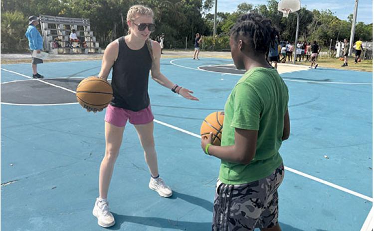 HCHS sophomore Tessa Murdock works one-on-one with a child from the Bahamas. (Callie Cueva/Staff)