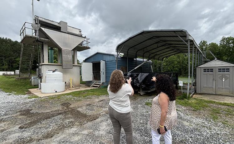 Baldwin’s Georgia Mountain Regional Commission Representative Laurin Yoder takes a picture of Baldwin’s wastewater treatment plant, while former mayor Stephanie Almagno accompanies her. Baldwin recently awarded the plant’s solids handling building project to Willow Dell LLC for $1.278 million. (Submitted)