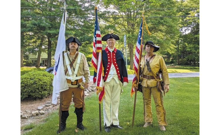 Brent Smith (left) holds the America 250 flag alongside Sons of the American Revolution Joseph Habersham Chapter member Dr. Ed Hendricks (middle) and Lyman Hall Chapter member David Lowden at the Mountain Laurel Festival Parade in Clarkesville. Smith tried to wear what he believed his grandfather would have worn in the war. (Submitted)
