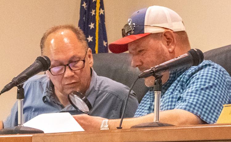 From left, Councilman Joe Elam takes a peek through Councilman Erik Keith’s magnifying glass at the newest budget numbers from City Manager Tiera Morrison and Finance Director Angela Adams. (Hannah Caudell/Staff)