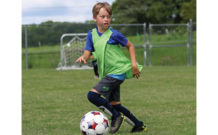 Raider soccer camper James Keane dribbles the ball during the Raider Soccer Academy Camp at Habersham Ninth Grade Academy on Friday, June 19. (Landen Todd/Staff)