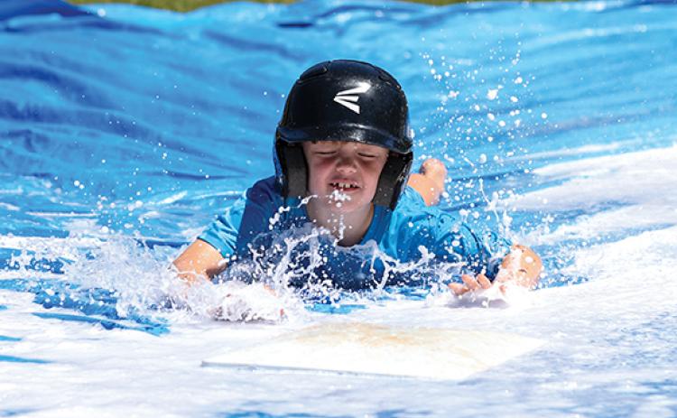 Camper Greyson Kempey slides head first during the TFS baseball summer camp. (Landen Todd/Staff)