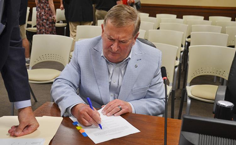 Habersham County Commission Chairman Bruce Harkness signs general obligation bond purchase documents. (Samantha Sinclair/Staff)