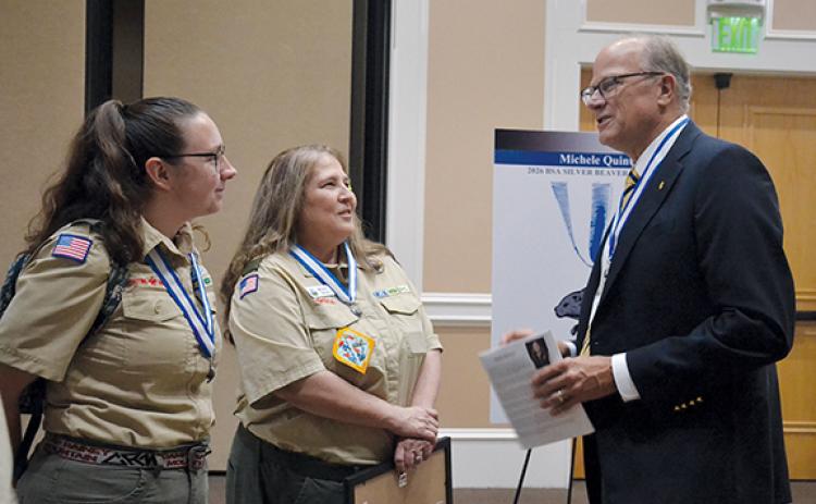 Council President Stewart Swanson (right) congratulates Michele Quintal (center) after the ceremony with Jessica Barnett. Barnett is the Scoutmaster for Troop 5231 in Snellville. (Samantha Sinclair/Staff)