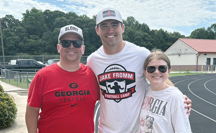 Chris Orr, left, and his daughter Abigail Orr, right, take a picture with former UGA quarterback Jake Fromm after Fromm’s youth football camp.  (Submitted)