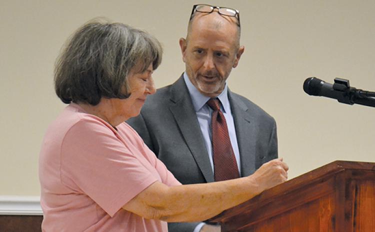 Martha Stuckey speaks about Cook Construction’s treatment of her as Cook Construction Attorney Vince Fitzgerald looks on. (Samantha Sinclair/Staff)