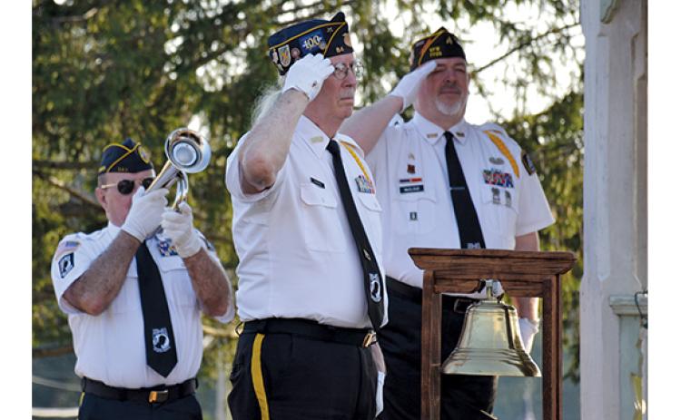 As Ken Franklin plays Taps, Dr. Ed Hendricks and Dana McCloud salute. (Samantha Sinclair/Staff)