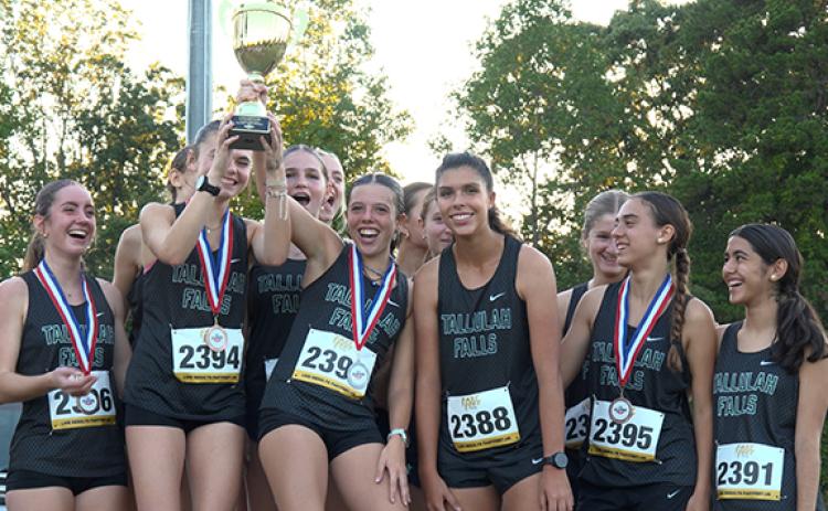 TFS runners Ida Patterson, Naomi Russo (in back), Avery Keim, Lily Denard, Mary Kate Ball (back), Olivia Henderson, Sofia Alderfer (back), Veronica Verberkmoes (back), Eloa Barbosa, Gabriella Corredera, (back), Leyre Martinez and Vega Encinas celebrate the consecutive region titles. (Submitted)