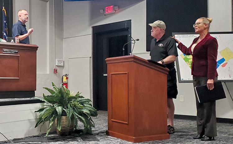 Councilman Donnie Bennett approaches the podium in an attempt to get Councilman Jimmy Davis, who is speaking at the podium, to conclude his message as Sherri McCullough tells council that Davis will continue to speak. (Samantha Sinclair/Staff)