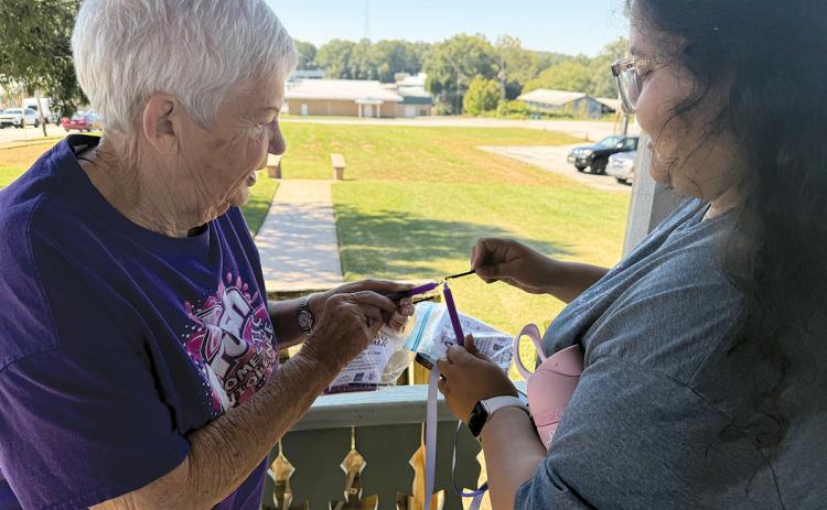 Myloe Moore and Tania Morales light a candle for domestic violence victims during Circle of Hope’s fifth annual Hope Walk held last week. (Submitted)