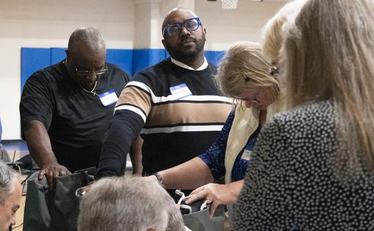 Shady Grove Baptist Church Pastor Sherrod Aiken, along with other volunteers, prays over the cots the Matthew 25 Alliance will use for the warming center as winter approaches. (Hannah Caudell/Staff)