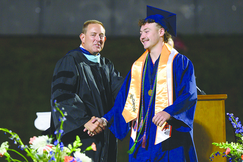 Dr. Jonathan Stribling shares a laugh with graduate Brody Tyree on Friday night. Stribling took a job as White County’s assistant superintendent. ZACH TAYLOR/Special