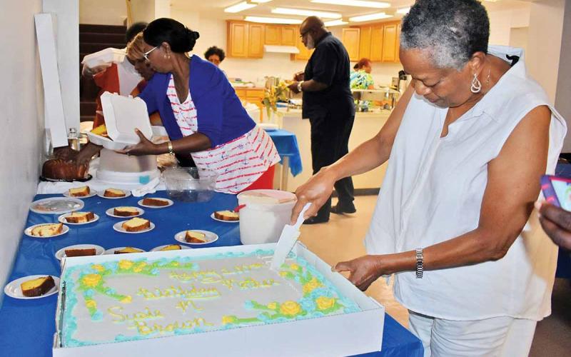 Gwen Brown, daughter of Susie Brown, cuts the cake at Susie Brown’s 100th birthday party earlier this month at a Clarkesville church. (Photo/CHAMIAN CRUZ)