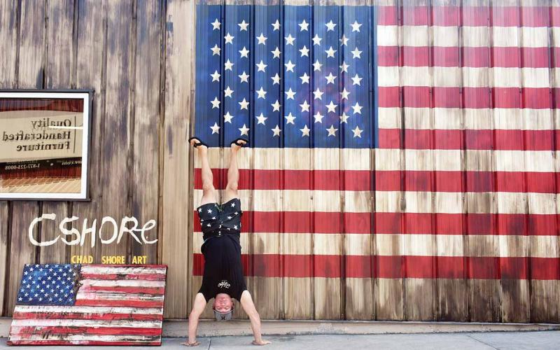 Artist Chad Shore does a headstand in front of his work. (Photo/Chamian Cruz)
