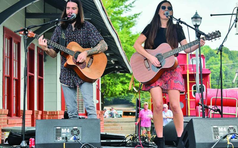 “Leaving Lennox,” comprised of Mick Hambly and Lauren Val, perform on stage in downtown Cornelia singing a song to the hundreds of attendees of the Big Red Apple Festival Saturday, Sept. 28. They sang a mix of covers and original songs. (Photo/CHAMIAN CRUZ)