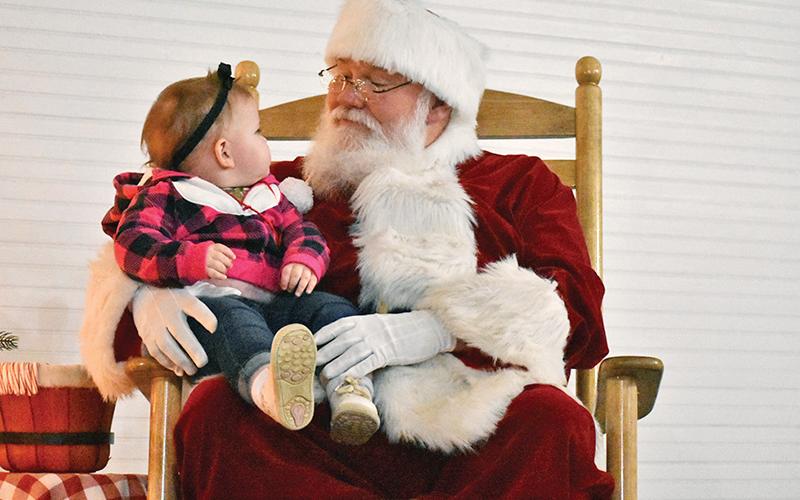 Santa Claus and 14-month-old Morgan Phillips of Demorest share a moment at the Christmas in Mt. Airy event Tuesday. Photo by Chamian Cruz