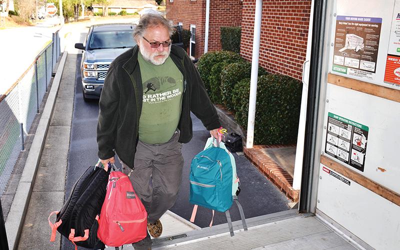 Volunteer Jack Treadman carries backpacks to the truck as part of Backpacks for Appalachia, a program to get gifts and supplies to kids in need at Christmastime.