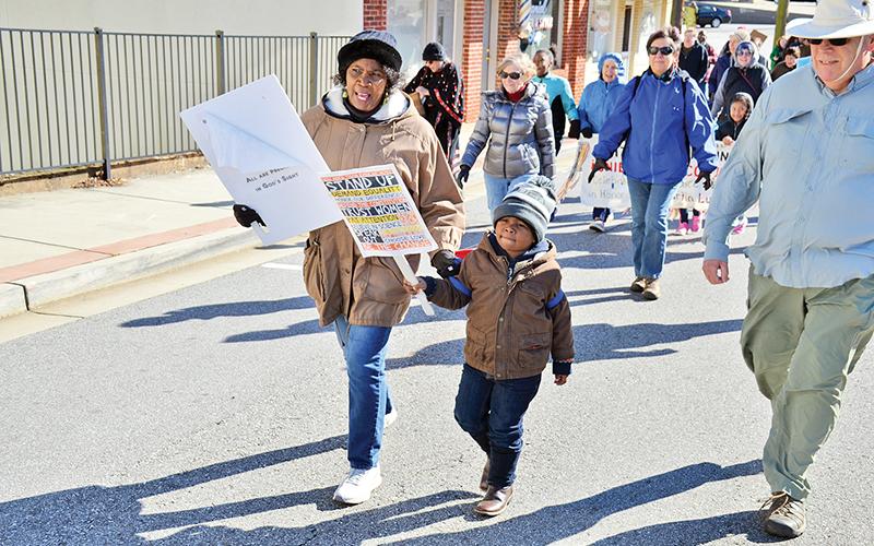 Vanessa Burns and Langston Mayfield walk in Sunday’s Dr. Martin Luther King Jr. Peace Walk in Cornelia. Mayfield represented a strong contingent of children who participated in the event.