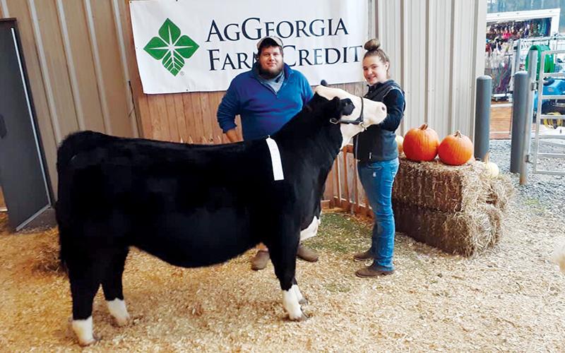William Crump, left, stands with Chesney Hamilton, a seventh-grade student at North Habersham Middle School and one of her show cows. Crump is a cattle broker and a teacher at Hilliard Wilbanks Middle School. He sponsors the Habersham County Dairy Team, and he also provides beef cattle.