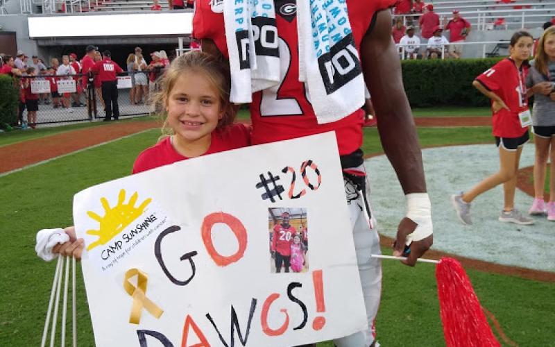Michaela Krippner, 11, of Mt. Airy, poses with University of Georgia safety J.R. Reed after his game.