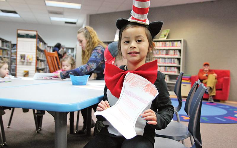 EJ Cesarone Thomas, 4, of Clarkesville presents her colored hat from The Cat in the Hat at the Clarkesville Library Dr. Seuss celebration on Thursday.