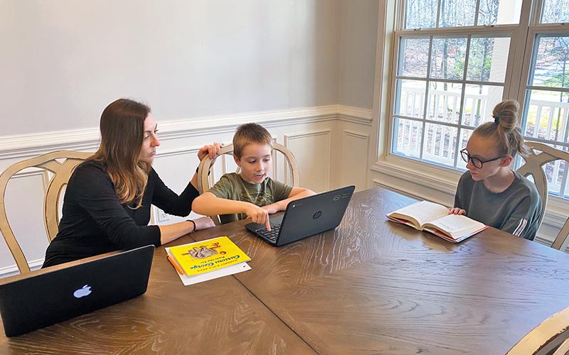Clarkesville Elementary teacher April Jones helps her children Zachary, 7, and Corie, 12, work on their school assignments from home. Jones teaches her second graders remotely as well during a busy daily routine.
