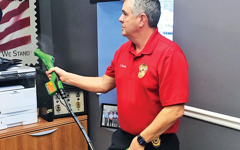 Chad Black, director of Emergency Services, demonstrates the Bioesque Botanical Disinfectant spray used to kill coronavirus on the person of EMTs and patients.