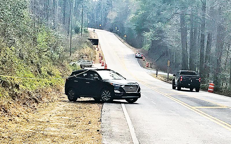 A car visiting the Panther Creek trailhead from the metro Atlanta area tries to pull out into the road Friday afternoon while getting stuck on the police line set up to deter visitors.