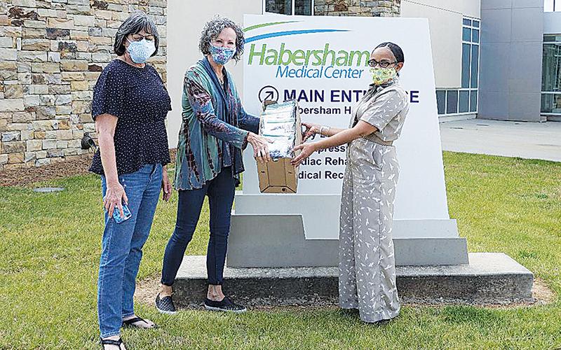 From left, Margie Williamson and Janice Mangimelli from Bethlehem Baptist Church offer mask covers to Kesha Clinkscale, Vice President of External Affairs at Habersham Medical Center.