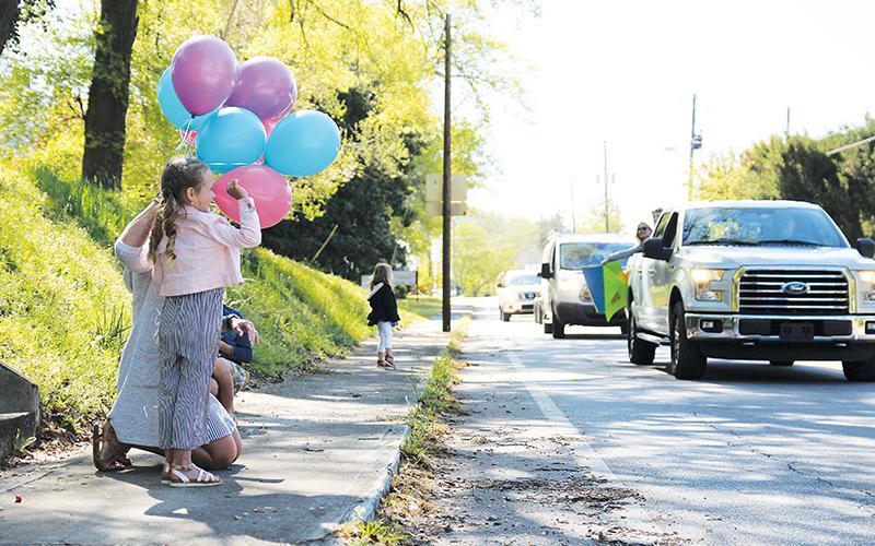 Ellie Jean Phillips and her mom Lizzy wave to friends and family at the birthday parade Friday in Clarkesville.