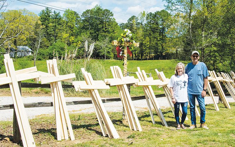 Sandy and Jimmy Turner stand with dozens of wooden crosses they’ve built as part of the “Faith Not Fear” movement. The crosses are free of charge to anyone who wants one. Donations for materials are accepted.