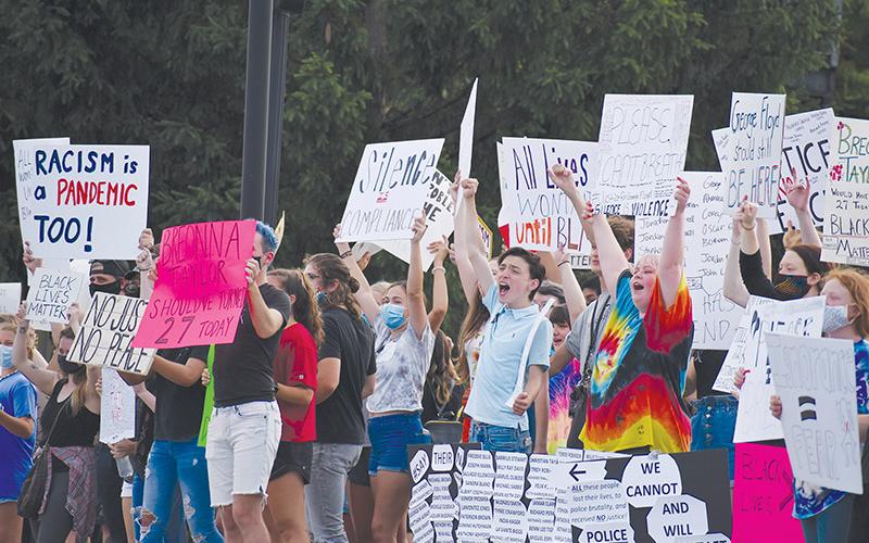 Demonstrators made their voices heard through signs, chants and songs Friday night in Clarkesville as they spoke out against racism. Photo by CODY ROGERS