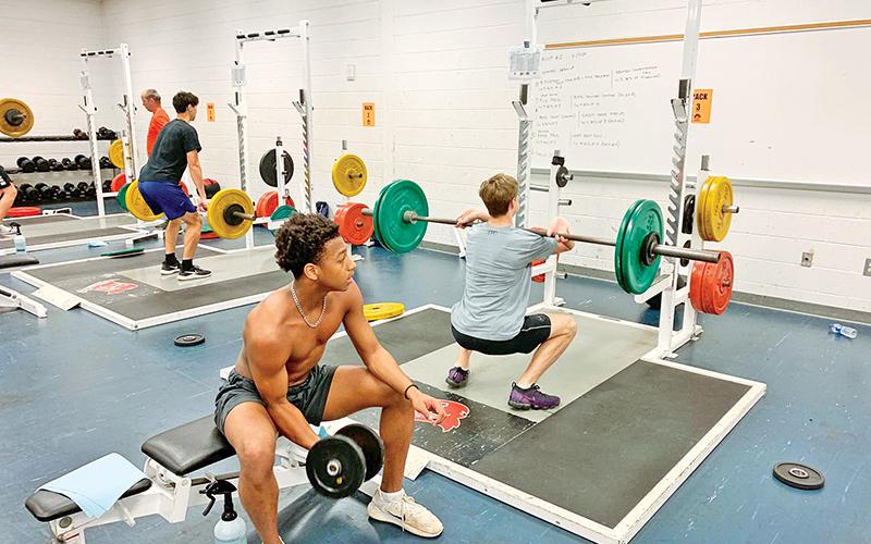 Habersham Central’s Malachi Dooley (middle) works on curls while Gunnar Bramlett (right) and Jacob Brown work on cleaning at the Habersham Central weight room earlier this week. 